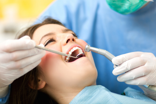 Dentist performing a screening on female patient